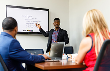 Student using a digital whiteboard to present a business idea.