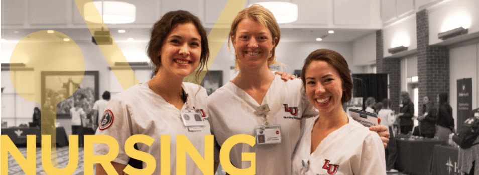 Three student nurses smiling at a career fair