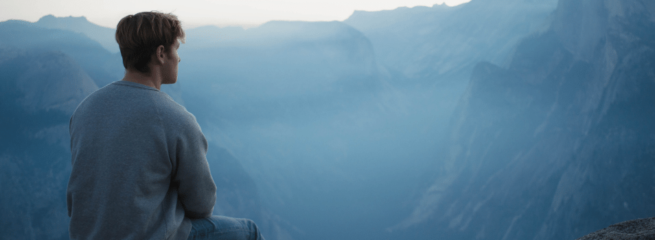 Man sitting outside looking at the mountains