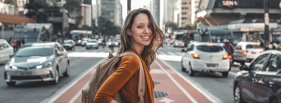 Woman standing in the street smiling over shoulder