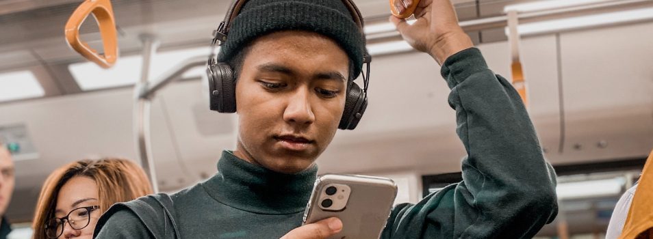 Man with headphones looking down at his smartphone