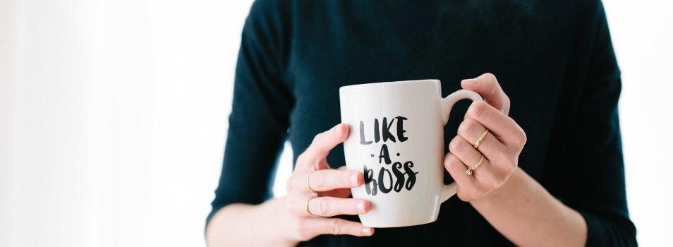 Woman holding a cup that says, "Like a Boss"