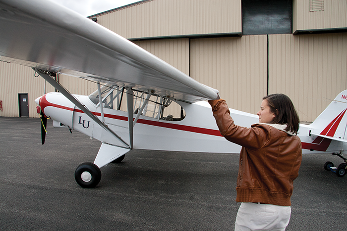 Super Cub — Former School of Aeronautics student Jodi Jacob checks out the Piper Super Cub involved in today's accident. The plane was donated by missionary couple Martin and Gracia Burham after they were imprisoned for a year in the Philippines. Martin was killed in a rescue attempt. Photo credit: Carter Bowns