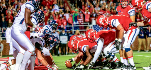 Trenches — Liberty Flames football team sets up for a goal-line push against Richmond in the 2014 Homecoming game. Photo credit: Leah Seavers
