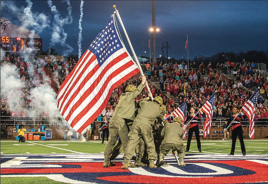 REMEMBRANCE — Students re-enacted the famous photo of the raising of the flag in Iwo Jima during the 2015 military appreciation football game. Photo Credit: Leah Seavers