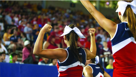 Commitment — Liberty cheerleaders display their team spirit during the football team’s loss at Kent State, Aug. 29. Photo credit: Ruth Bibby