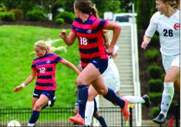 Jubilee — (Top) Lady Flames celebrate after scoring against Campbell. (Bottom) Sophomore midfielder Rebekah Page winds up to deliver a pass. Photo credit: Courtney Russo