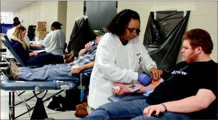 GIVE — Students help during a blood shortage by giving blood in the back of DeMoss Hall. Photo credit: Abby Kourkounakis