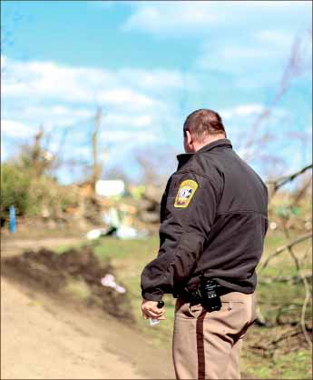 Resilient — Appomattox officer and grandson of Keith Harris, who died in the storm, looked at the damage. The officer was the first to find his grandfather’s body. Photo credit: Leah Seavers