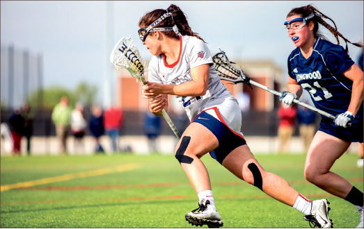 Positioning — Abby Britton carries the ball down the field in the Lady Flames win over Longwood. Photo credit: Leah Seavers