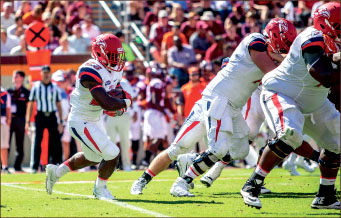 ON THE RUN — Frankie Hickson carries the ball behind the Flames’ offensive line. Photo credit: Michela Diddle