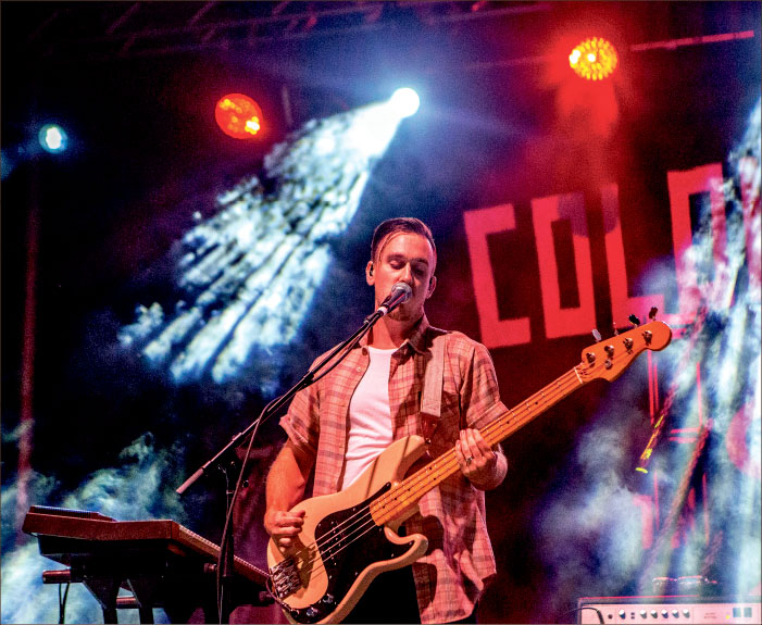 PLAYING HIS HEART OUT — Colony House bassist Parke Cottrell provided bass and backup vocals at the Sept. 3 concert held in the LaHaye Student Union parking lot. Photo credit: Caroline Sellers
