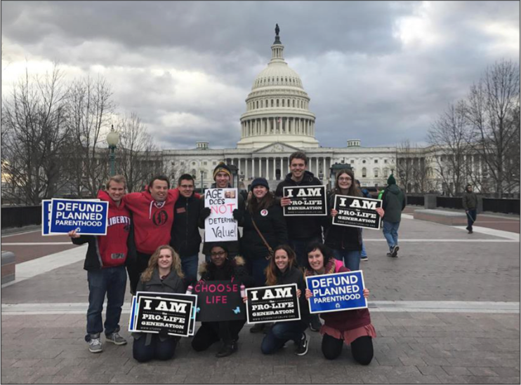 RAISE AWARENESS — A group of Liberty students held signs in front of the Capitol. Photo Provided