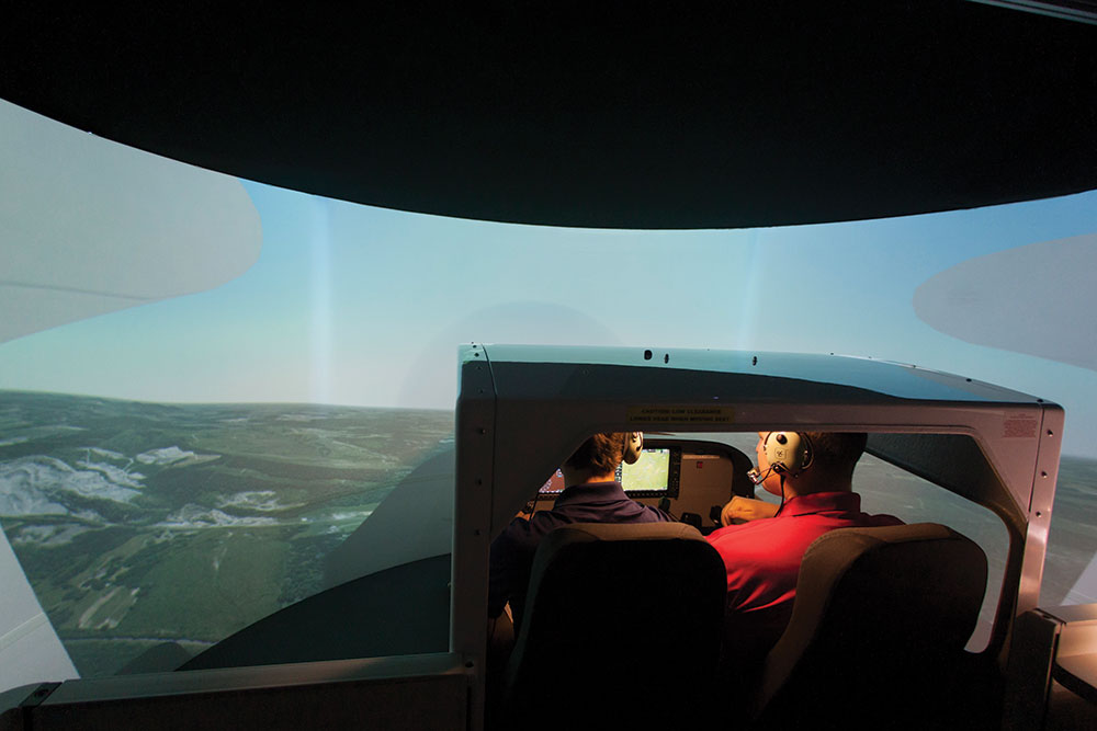 An aeronautics student and instructor train in one of Liberty's flight simulators.
