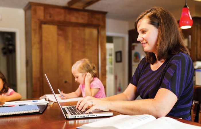 A family studies together in the kitchen.