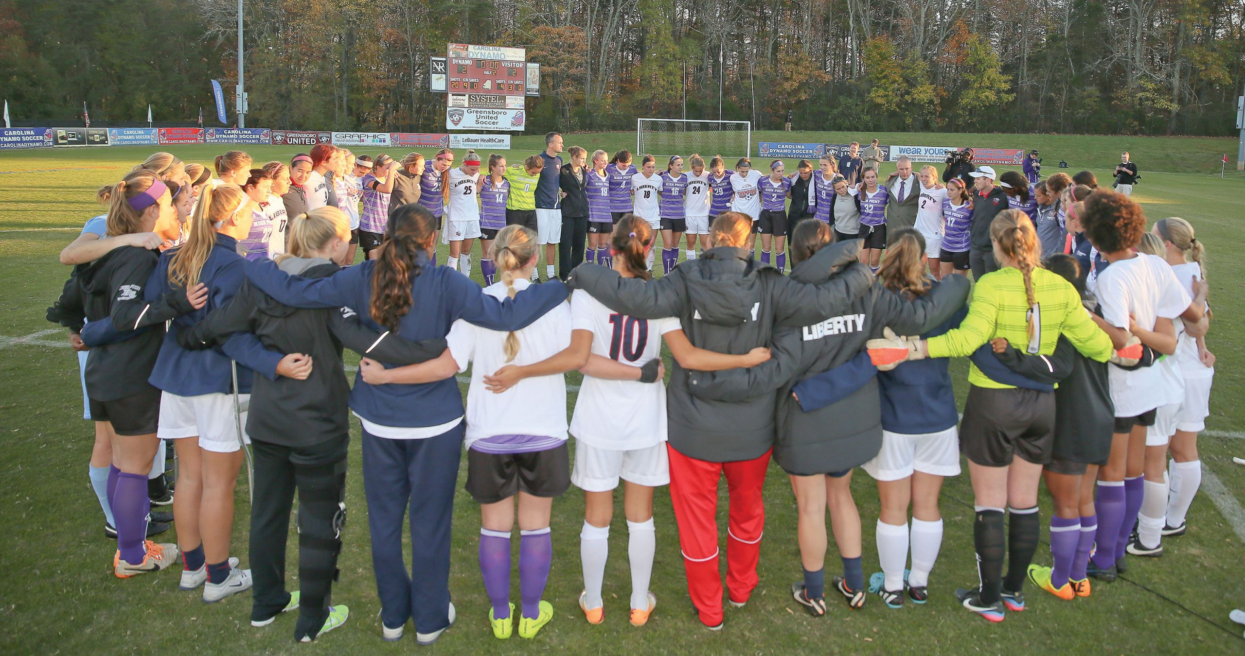 The Lady Flames join High Point players at the end of the Big South Championship game on Nov. 9.