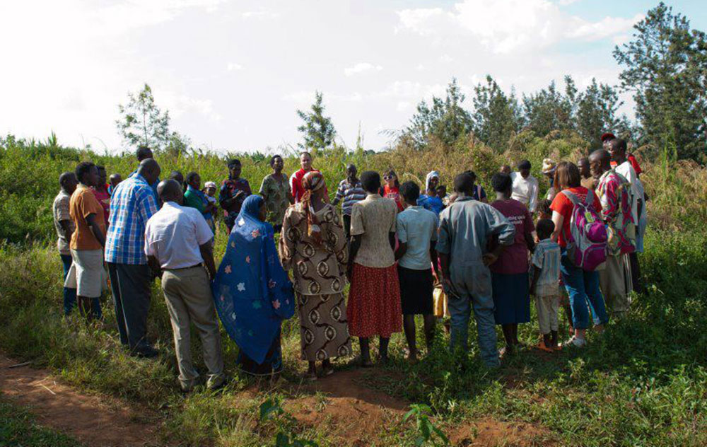 Students join hands with residents of Kigali, Rwanda, to dedicate a school being funded by Liberty University students, faculty, and staff.