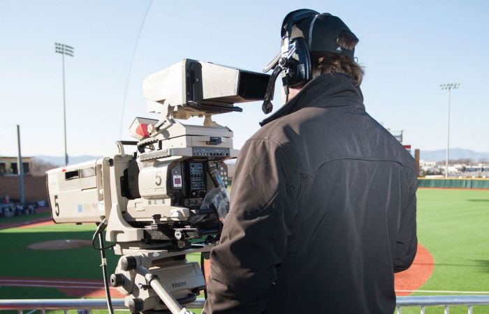 A cameraman covers a baseball game for LFSN.