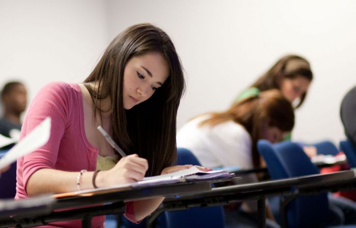 A Liberty student takes notes during class.