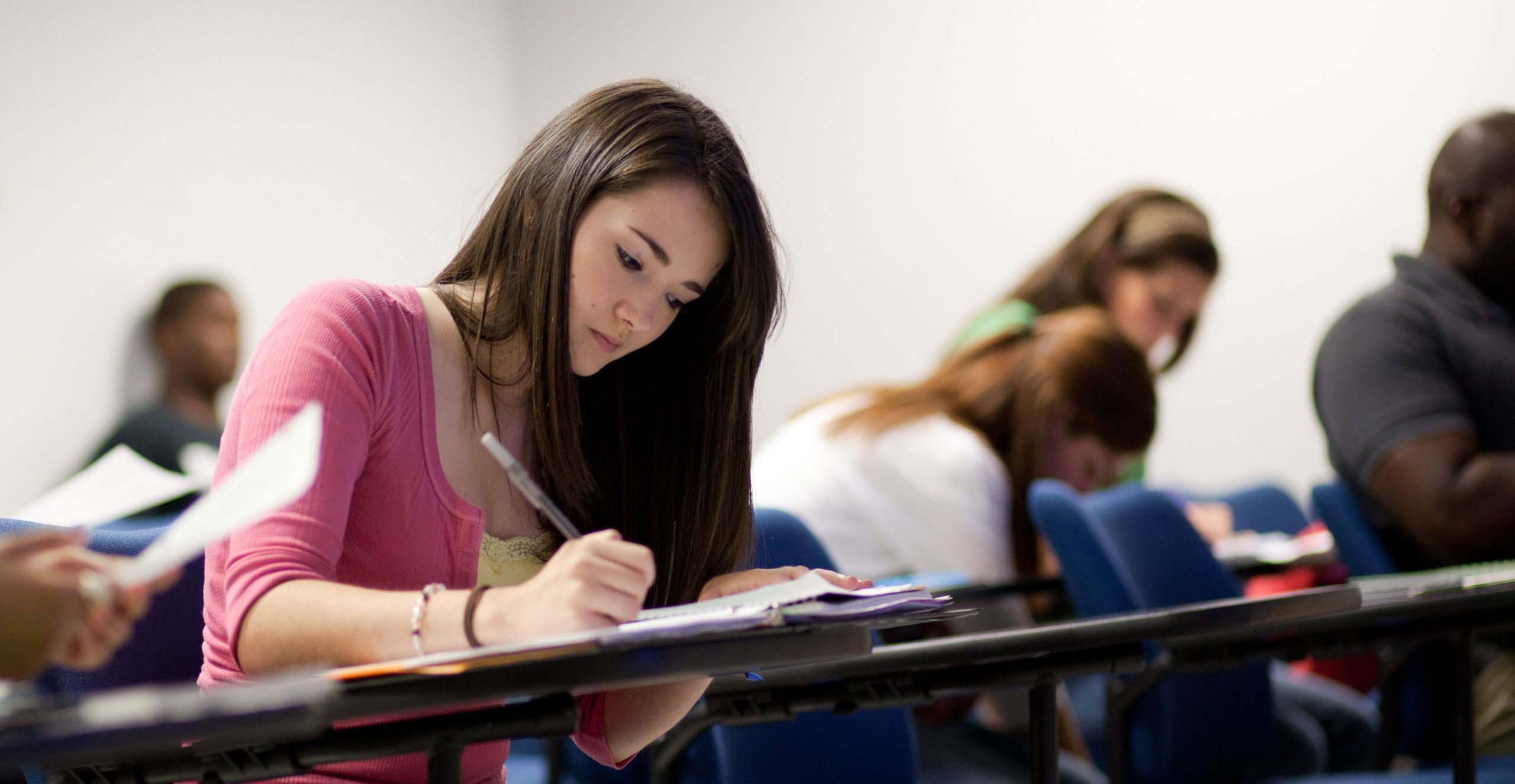 A Liberty student takes notes during class.