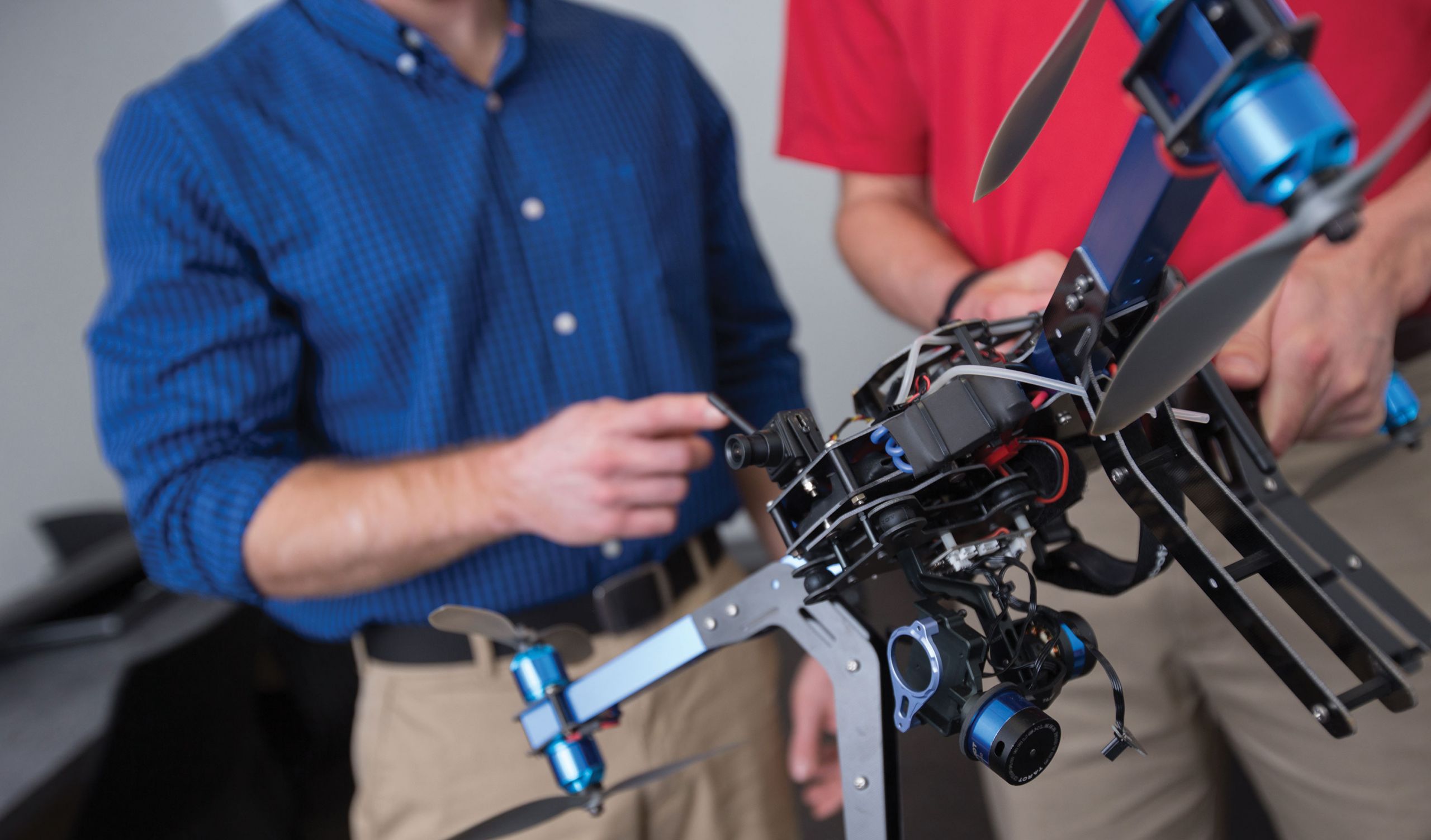 A Liberty University professor and student work with a 3D Robotics Y6 unmanned aerial vehicle.