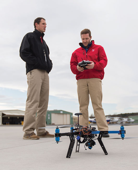 Jacob Miller (right), a senior in the School of Aeronautics’ UAS program, gets some hands-on experience with a 3D Robotics Y6 unmanned aerial vehicle under the supervision of professor Jonathan Washburn.