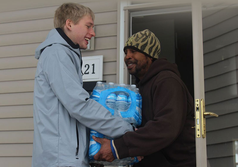 Junior Daniel Trotter delivers water to a resident of Flint, Mich.
