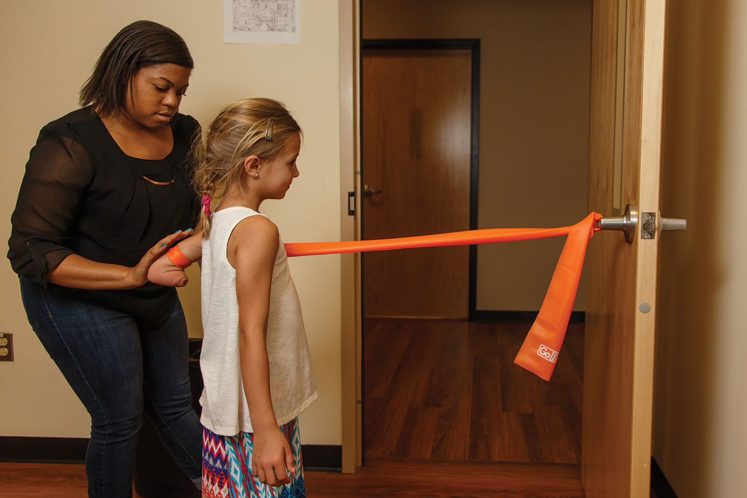 Alexis Love, a rising exercise science junior, helps Maddie Rebsamen with some muscle-strengthening exercises.