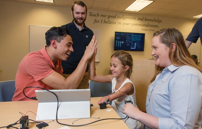 Liberty University rising junior Adam Morrone high-fives Maddie Rebsamen.