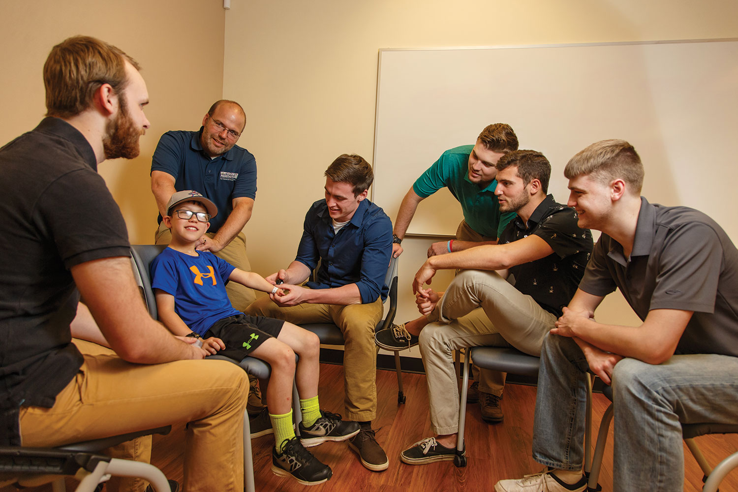 Members of the attachment and usability team take measurements from 8-year-old Connor McCombs.
