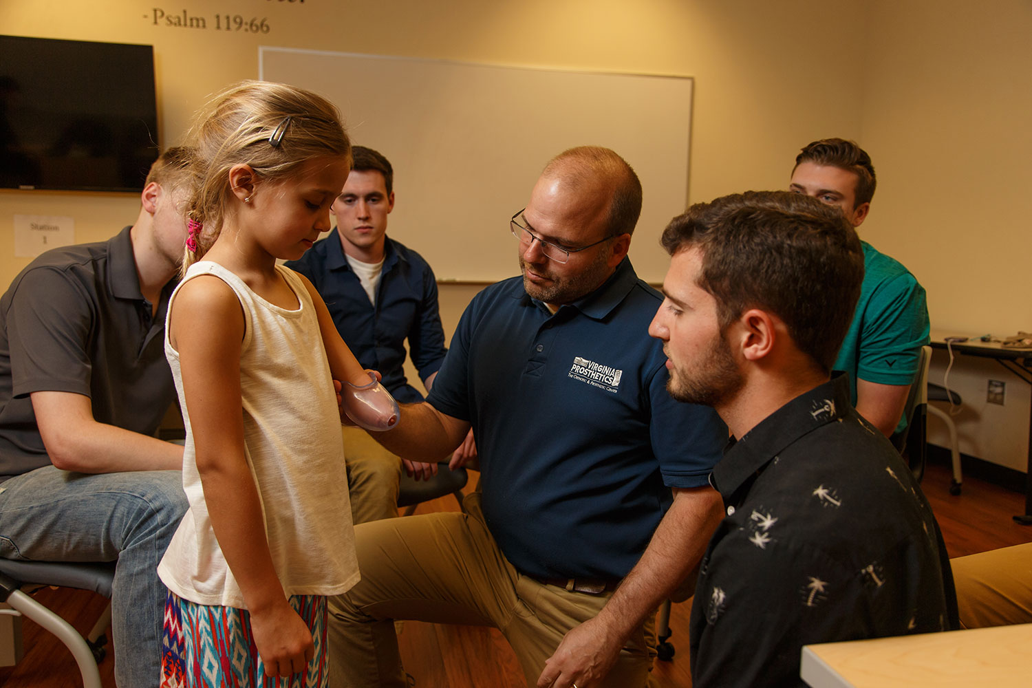 Eli Rogers, CPO with Virginia Prosthetics and Orthotics, helps Nick Losee assess comfort and attachment ideas for Maddie's Exo-Arm.