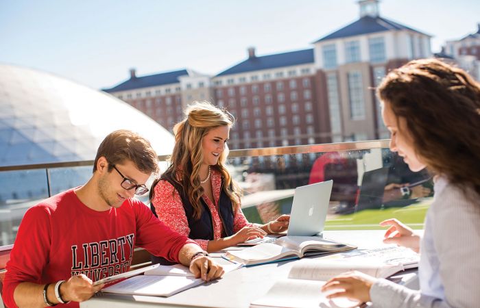 Austin Olson (left), Kasey Jackson, and Caitlin Parsons study on a balcony at the Jerry Falwell Library.