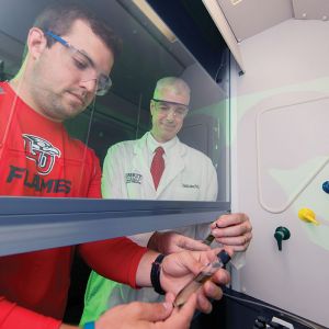 Dr. Todd Allen, associate professor of chemistry, works with recent graduate Grant McClure on research related to the conversion of algae to biofuels.