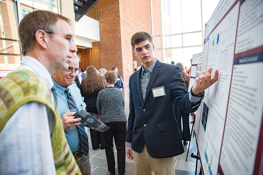 Undergraduate biomedical sciences student Taylor Lonjin presents a research poster.