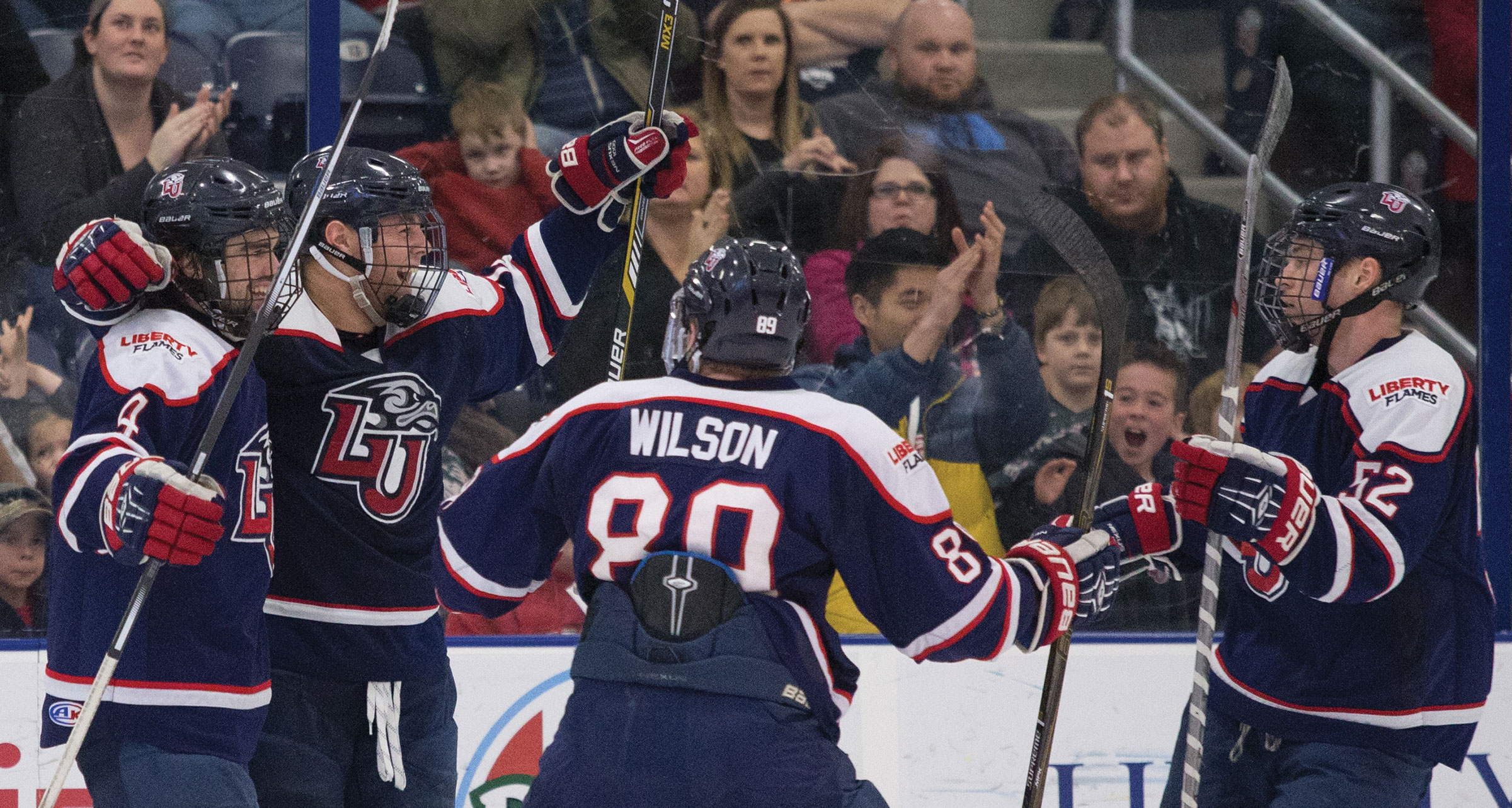 Liberty Flames men's ice hockey players celebrate.