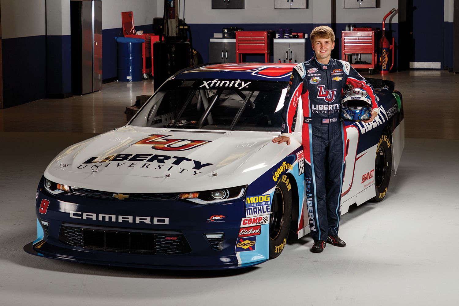 Liberty University freshman William Byron stands with the new Liberty University No. 9 Chevy Camaro he will drive during his rookie season with JR Motorsports (JRM) on the Xfinity Series.