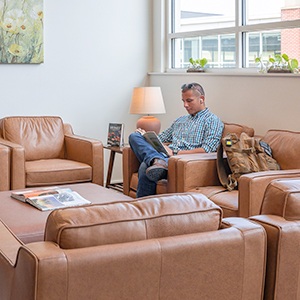 Student sitting and reading a book in one of the new "living room" spaces in the Jerry Falwell Library