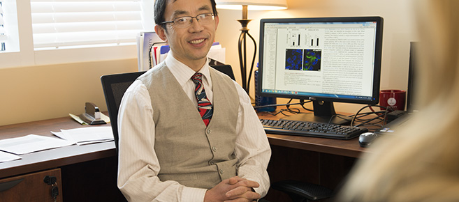 Dr. Liu addresses a student doctor about research opportunities.