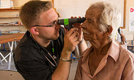 Student-doctor David Winston examine's a patient's eyes.