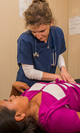 Student-doctor Megan Hoffer assists a female patient.