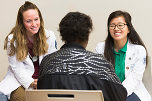 LUCOM student-doctors listen to patient.