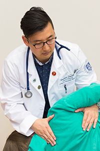 LUCOM student-doctor treats patient, osteopathic manipulative medicine.