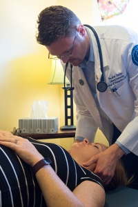 LUCOM student-doctor Matthew Boyle performs OMT on patient.