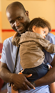 LUCOM student-doctor embraces a Guatemala child.