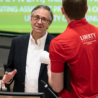 James A. Avery, MD, CMD, FAAHPM, FCCP, FACP, speaks to a Liberty University osteopathic medical student following his presentation titled “Marijuana: An Honest Look at the World’s Most Misunderstood Weed” on March 1, 2022.