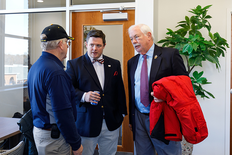 Jesse MacDonald (center) speaks with guests at the grand opening of the Veterans Center