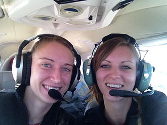 Megan Grupp and Jessica Dyer, coach of the Liberty Belles, pose in their cockpit.