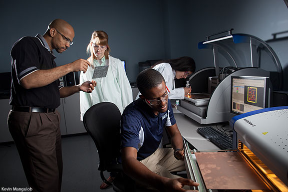 Computer engineering students learn from a professor in Liberty University's engineering lab.