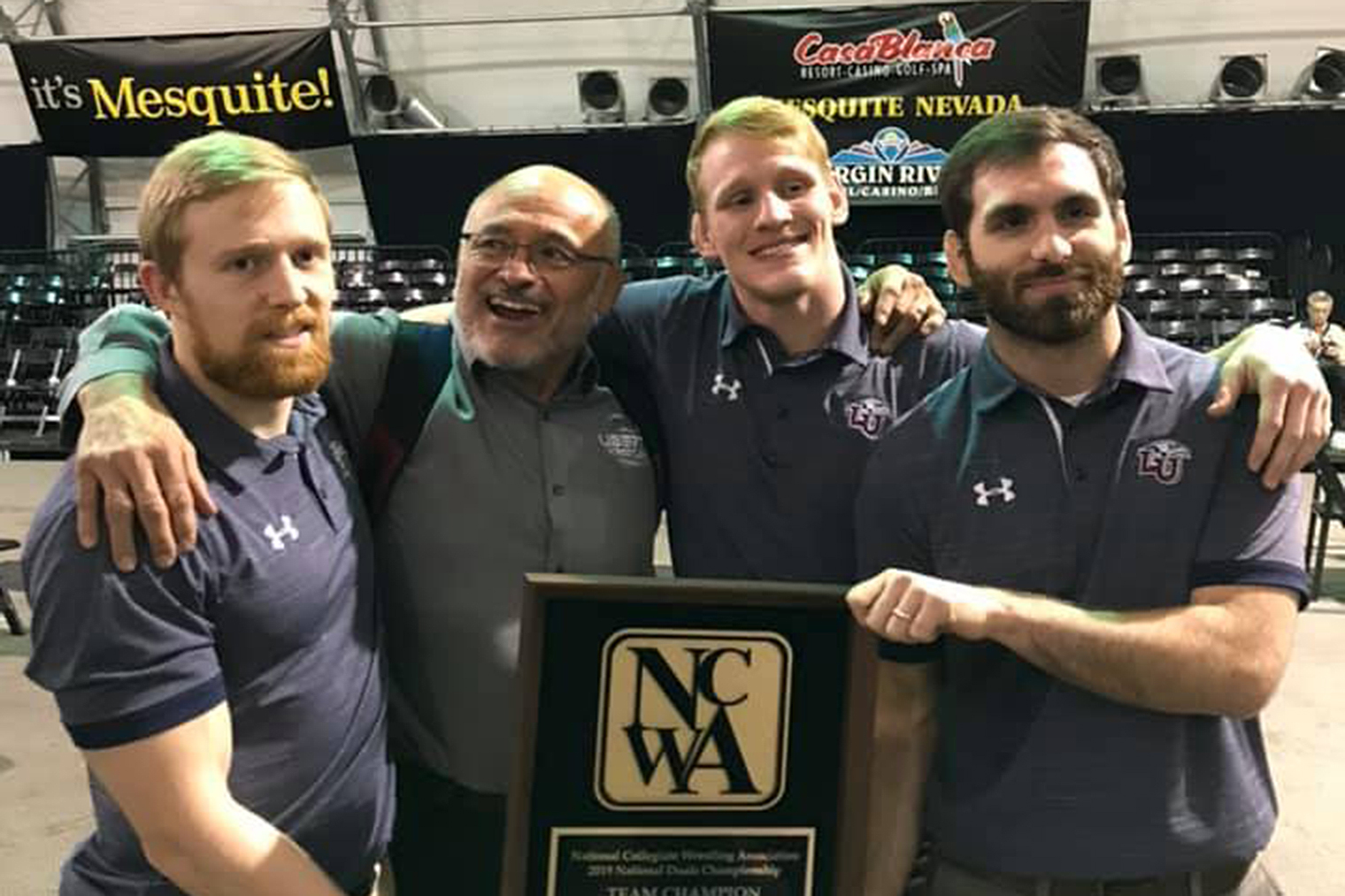 Liberty men's wrestling Head Coach Jesse Castro (second from left) celebrates the Flames' successful NCWA National Duals title defense Saturday in Mesquite, Nev. (Submitted Photo)