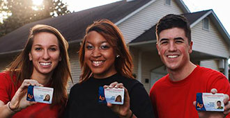 Liberty University students hold Flames Pass student ID cards.